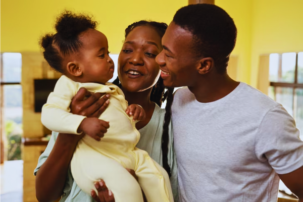 Adorable Black baby at home with loving parents, highlighting the positive impact of Family Planning Services on creating healthy, well-prepared families