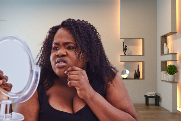 Young African woman looking distressed due to skin issues and weight gain, common symptoms associated with hormonal imbalance