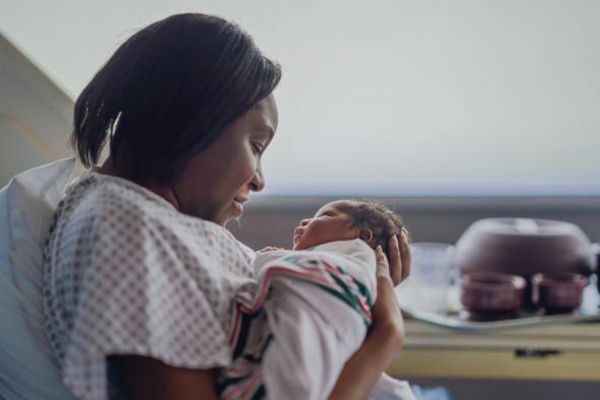 A joyful mother holding her newborn baby, highlighting the emotional reward after undergoing fertility treatment and exploring the cost of IVF in Nigeria